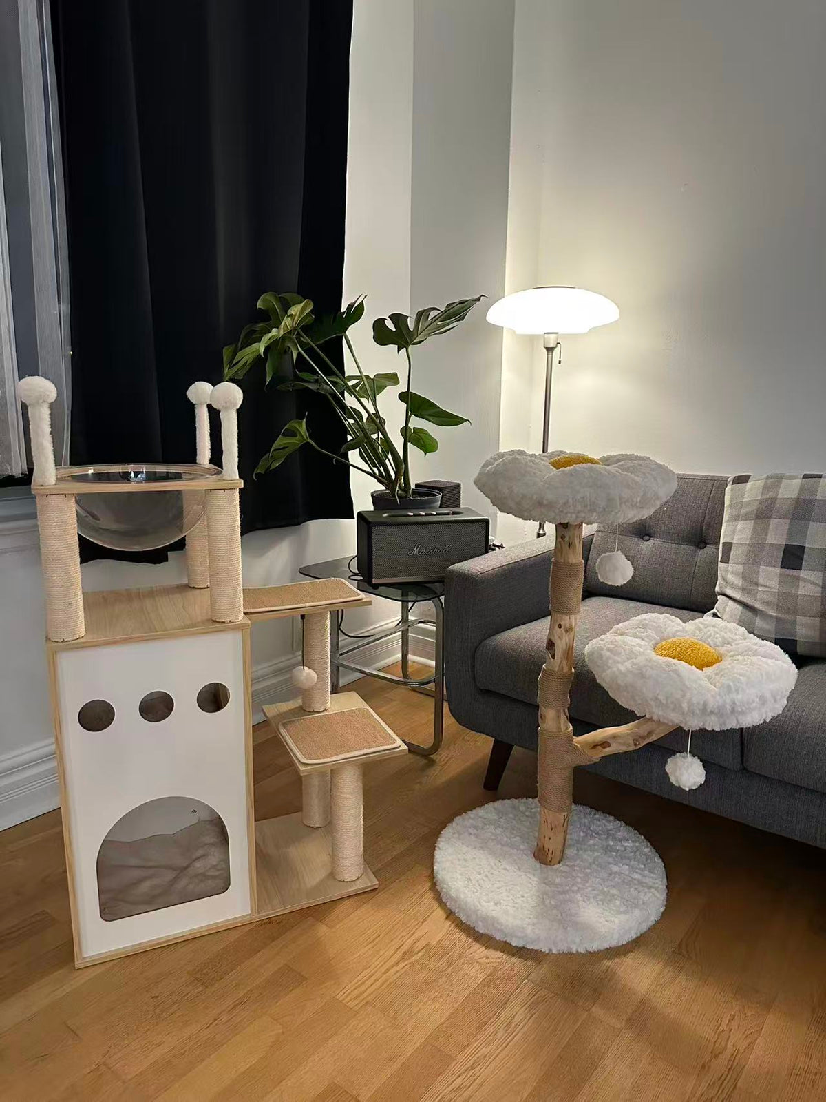 Cat tree with multiple levels and a fluffy top in a living room setting.
