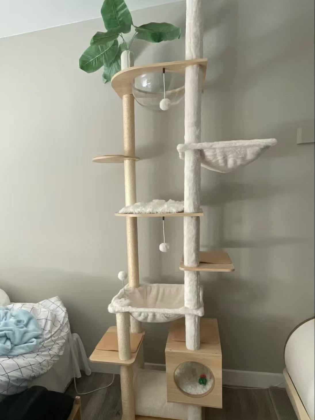 Cat tree with multiple levels and a small hideout in a room.